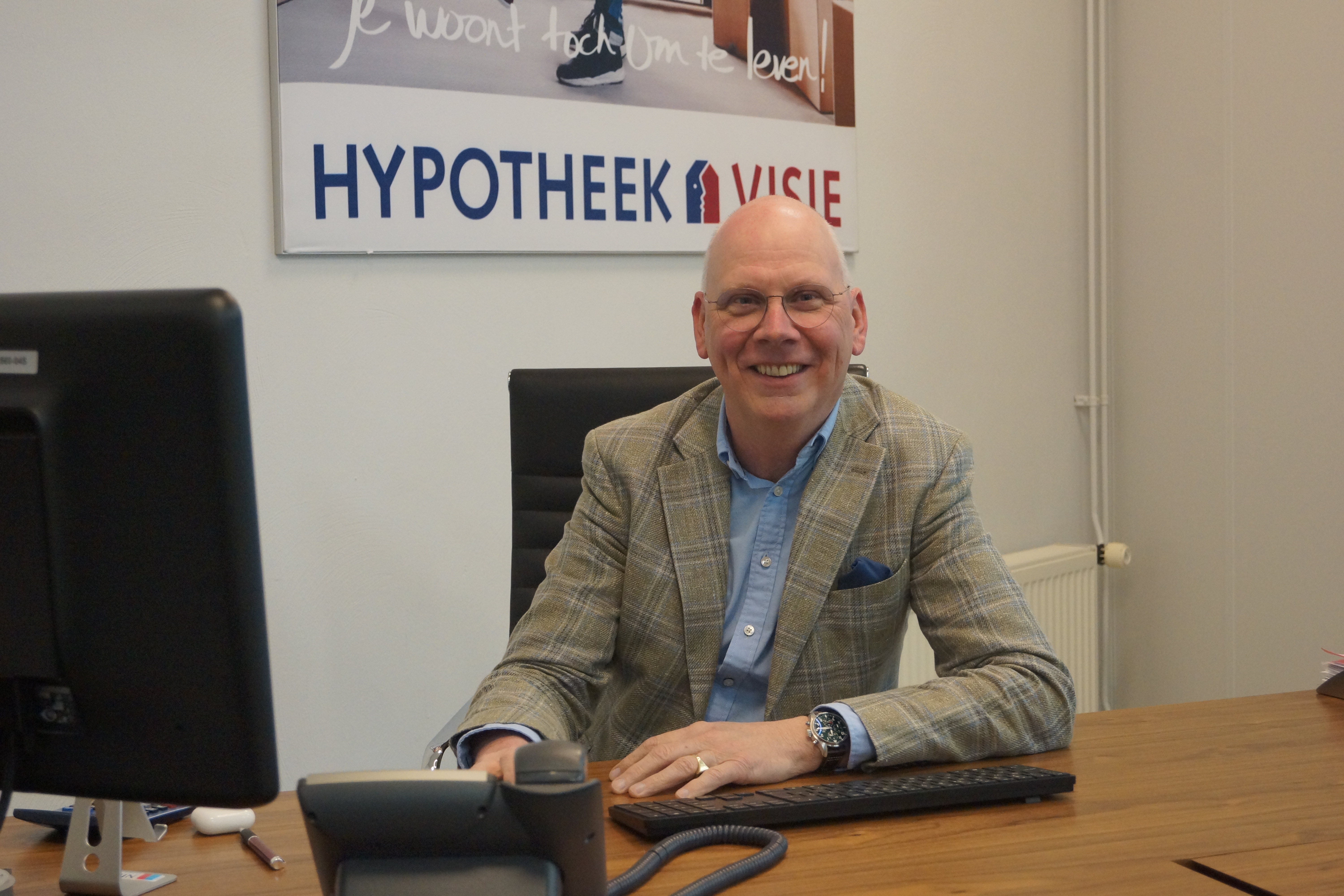 Man zit achter bureau en lacht