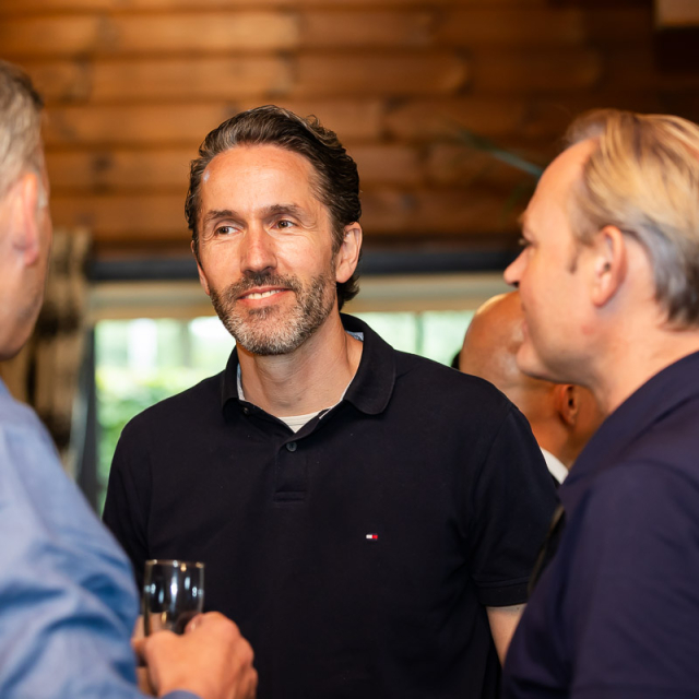 Mannen zijn met elkaar in gesprek en kijken elkaar aan.