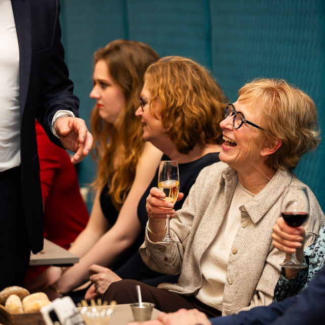 Vrouwen zitten naast elkaar en lachen