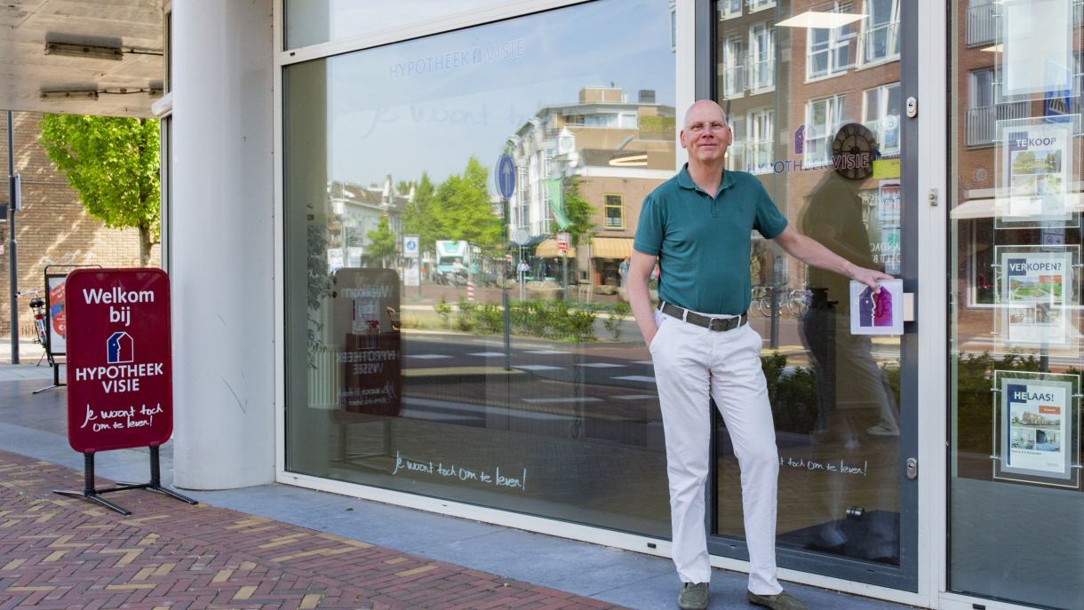 Man staat voor een deur en houd de deurknop vast